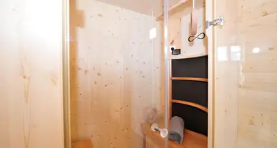 a room with a shower with a wooden wall at Camping Chalet Salten in San Genesio Atesino