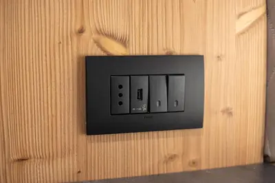 an electrical outlet on a wooden wall at Hotel Villa Melì in Predazzo