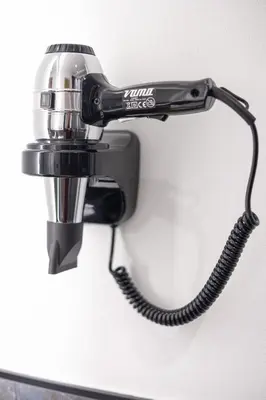 a hair dryer hanging on a wall at Hotel Villa Melì in Predazzo