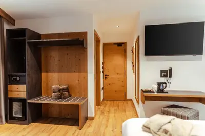 a living room with a tv on the wall at Hotel Villa Melì in Predazzo