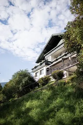 a living room with a chair and a window at Alpstay - Chalet Hotel Hartmann - Adults Only in Ortisei