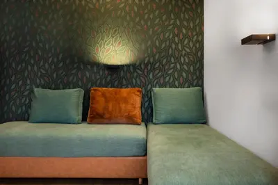 a couch with two pillows on it in a room at Ciasa Anteriol NEW SUMMER 2025 in San Cassiano