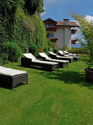 a row of chaise lounges on the grass in a yard at Aktiv & Relax Hotel Hubertus in Villandro
