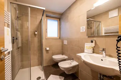 a bathroom with a sink and a toilet and a shower at B&B Hotel Sonneck in Naz-Sciaves