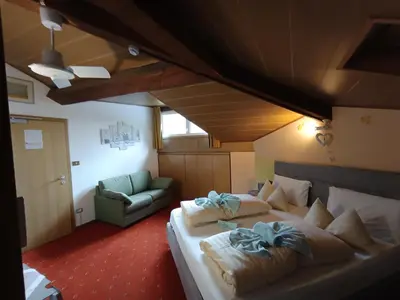 a hotel room with a bed and a couch at Hotel Residence Rosa in San Lugano