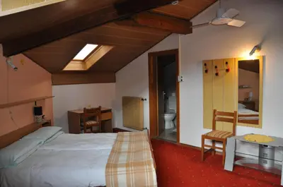 a bedroom with a large bed and a bathroom at Hotel Residence Rosa in San Lugano