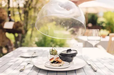 a person holding a bubble over a plate of food on a table at Hotel Restaurant Langgenhof in Brunico