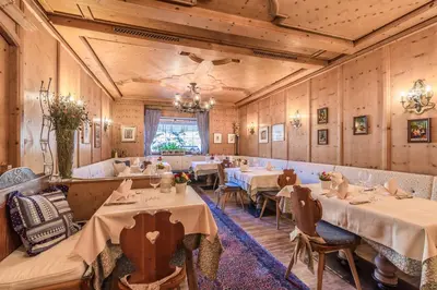 a restaurant with tables and chairs in a room at Hotel Restaurant Langgenhof in Brunico
