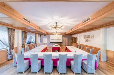 a conference room with a large table and chairs at Hotel Restaurant Langgenhof in Brunico