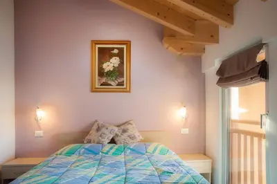 a bedroom with a bed and a picture on the wall at b&b Casa Tavernaro in Fiera di Primiero