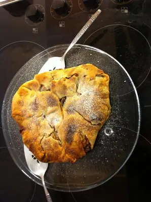 a pie is being cooked in a pan with a spoon at b&b Casa Tavernaro in Fiera di Primiero