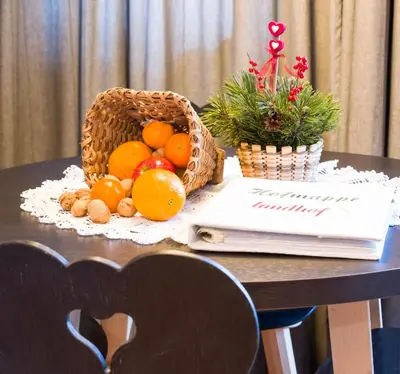 a basket of fruit on a table with a book at Landhof in Monguelfo