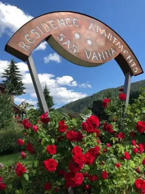 a sign for an entrance to a garden with red roses at Residence Sas Vanna in La Villa