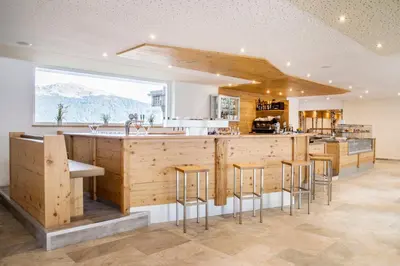 a kitchen with a large island with bar stools at Sporthotel Kalcherhof in Racines