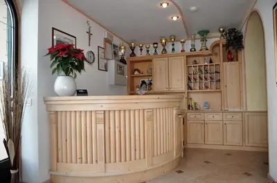 a kitchen with wooden cabinets and a counter with a vase at B&B Apartments La Palsa in San Cassiano