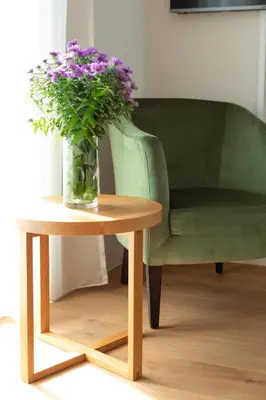 a vase of purple flowers on a table next to a chair at Untermargarethenhof in Lana