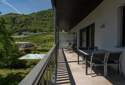 a balcony with a table and chairs and a pool at Untermargarethenhof in Lana