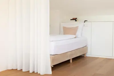 a bed with white curtains in a room at Untermargarethenhof in Lana