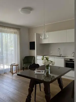 a kitchen and living room with a table with flowers on it at Untermargarethenhof in Lana