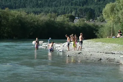 a group of people standing on the shore of a river at Gruppenhaus Thalackerhof in Brunico