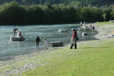 a group of people standing on the shore of a river at Gruppenhaus Thalackerhof in Brunico