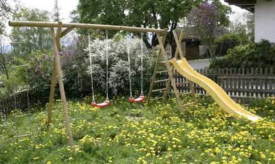 a swing in a garden with yellow and red swings at Gruppenhaus Thalackerhof in Brunico