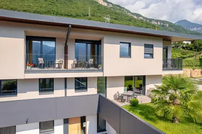 an aerial view of a building with mountains in the background at Tholr - Ferienwohnungen - Tramin in Termeno