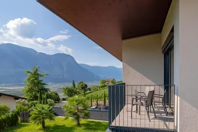 a balcony with chairs and a view of mountains at Tholr - Ferienwohnungen - Tramin in Termeno