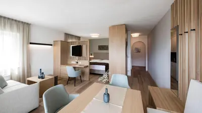 a living room with a table and a bedroom at Appartementhaus Residence Hirzer in Tirolo