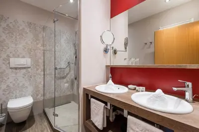 a bathroom with two sinks and a shower at Appartementhaus Residence Hirzer in Tirolo