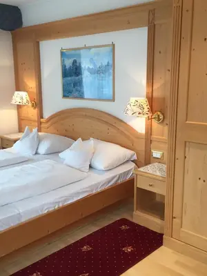 a bedroom with a bed with white pillows at Garni Franca b&b in Selva di Val Gardena