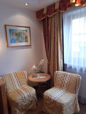 a room with two chairs and a table and a window at Garni Franca b&b in Selva di Val Gardena