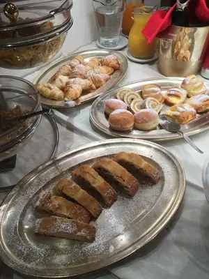 a table topped with plates of pastries and donuts at Garni Franca b&b in Selva di Val Gardena