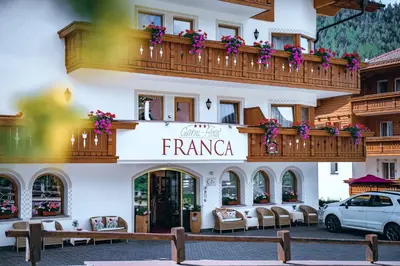 a building with a balcony with flowers on it at Garni Franca b&b in Selva di Val Gardena