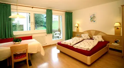a bedroom with a bed and a table and a window at Medesc in La Villa