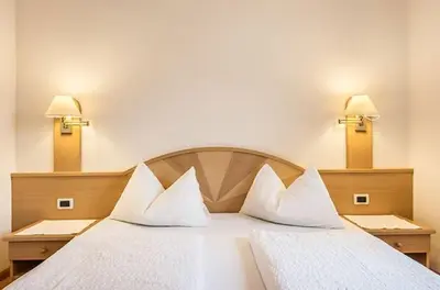 a bedroom with a large white bed with two pillows at Medesc in La Villa