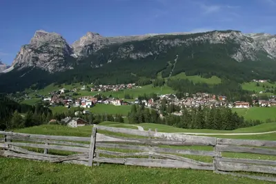 a fence on a hill with a village and mountains at Medesc in La Villa