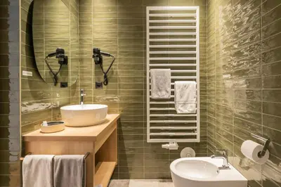 a bathroom with a sink and a toilet and a mirror at Gasthof Albergo Dolomiten in Braies