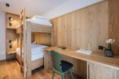a room with a desk and bunk beds at Gasthof Albergo Dolomiten in Braies