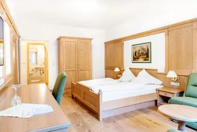 a bedroom with a bed and a table and chairs at Hotel Goldenes Roessl-adults only in Bressanone