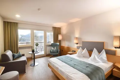 a hotel room with a bed and a chair at Hotel Das Stachelburg in Parcines