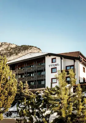 a hotel building with trees in front of it at Hotel Tyrol in Selva di Val Gardena