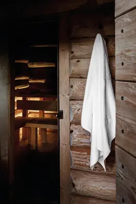 a white towel hanging on a wooden wall at Hotel Tyrol in Selva di Val Gardena