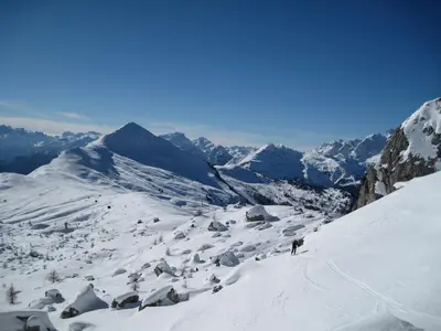 a person is skiing down a snow covered mountain at Hotel Albe in Rocca Pietore