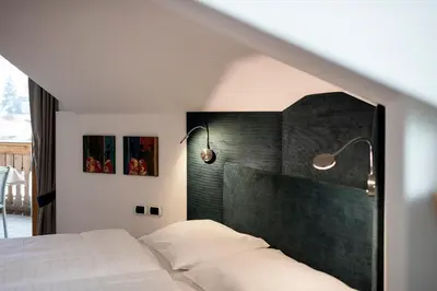 a bedroom with a bed with two lights on the wall at Villa Aurelia in Ortisei