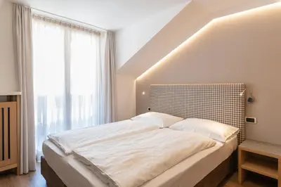 a bedroom with a large bed with a large window at Villa Aurelia in Ortisei
