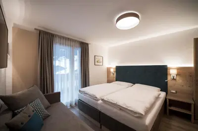 a bedroom with a bed and a couch at Villa Aurelia in Ortisei