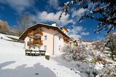 a building with a balcony in the snow at Residence Villa Boschetto in Carano