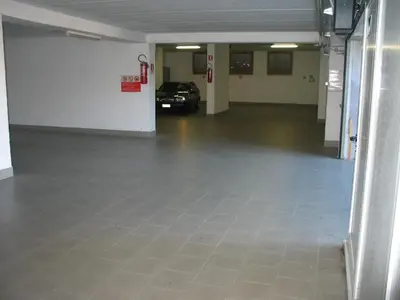 an empty garage with a car parked in it at Residence Villa Boschetto in Carano