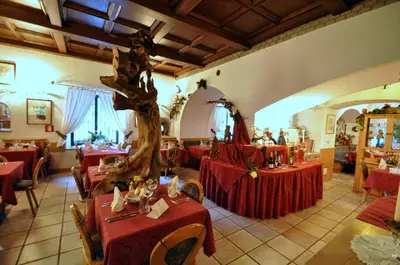 a restaurant with two tables with red table cloths at Hotel Al Forte in Arabba
